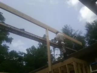 Carpenter setting a ridge beam over a new addition frame — Ice Dam Removal by Roofing Brothers in Hunt