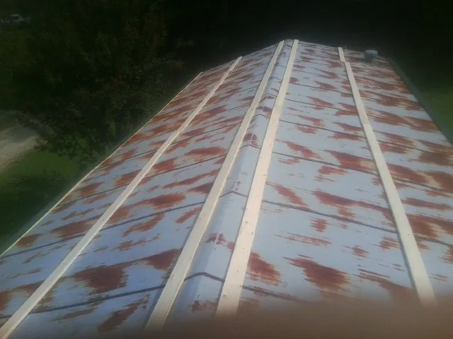 Rusted metal roof panels with new wood purlins before replacement — Storm Damage Roof Repair in Hunt by Roofing Brothers